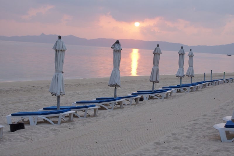 パラソルの並ぶ砂浜の夕日