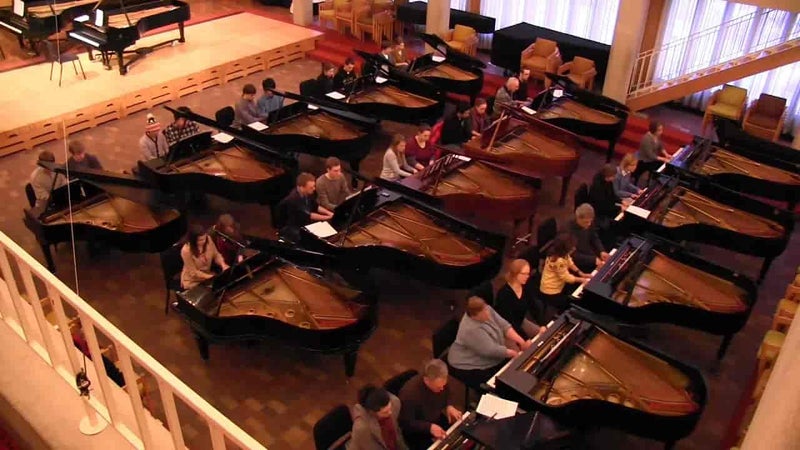 並べられた15台のグランドピアノを連弾演奏している様子を、吹き抜けの2階から写した写真