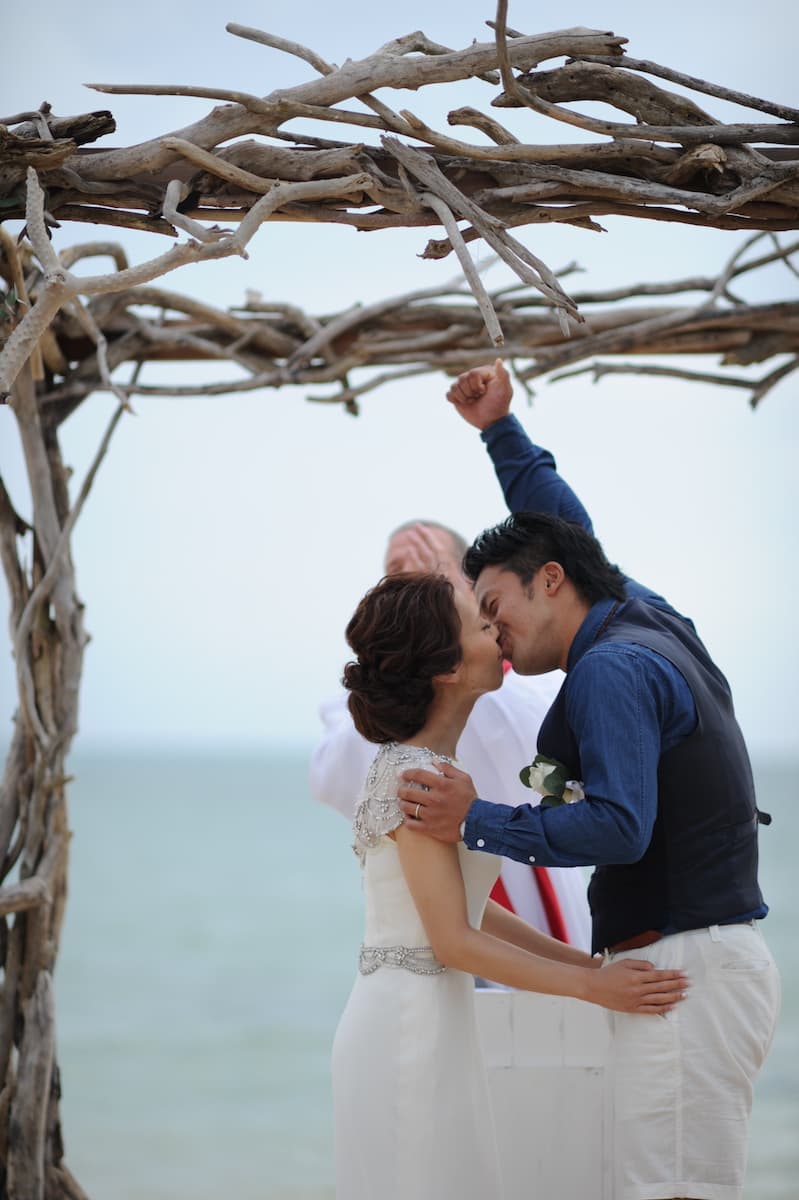 石垣島の海岸でキスをする新郎新婦